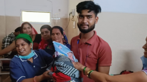 सतना के निजी अस्पताल में स्वस्थ नवजात को गोद में लिए पिता, महिला मेडिकल स्टाफ और परिजन साथ में मुस्कुराते हुए