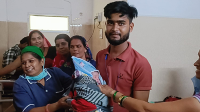 सतना के निजी अस्पताल में स्वस्थ नवजात को गोद में लिए पिता, महिला मेडिकल स्टाफ और परिजन साथ में मुस्कुराते हुए