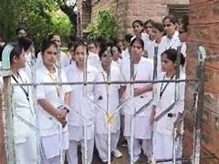गेट के बाहर एकत्रित नर्सिंग छात्राएं, लैंगिक उत्पीड़न के विरोध में प्रदर्शन करती हुईं।