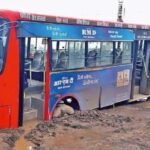 भोपाल पटेल नगर में धंसी सड़क के गड्ढे में फंसी नगर निगम की बस — सड़क की जर्जर हालत और PWD की लापरवाही का उदाहरण।